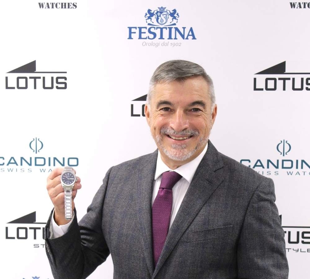 Ritratto sorridente di Paolo Galimberti Direttore Generale Festina Italia che mostra un orologio della sua azienda